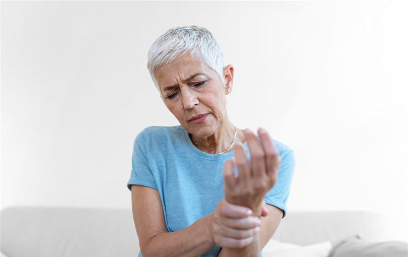 Older woman holding a stiff, painful wrist